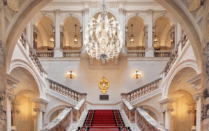 Great chandelier hangs above marble staircase at The OWO, lighting by Lutron