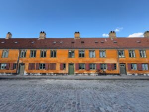 a building with windows and a bicycle parked on a cobblestone street